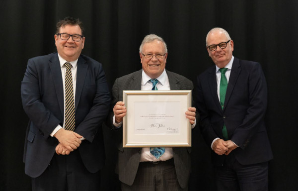 A staff member holding a certificate