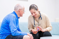 a doctor showing a patient a model heart